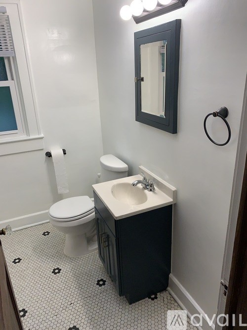 A white toilet sits next to a sink in a bathroom.