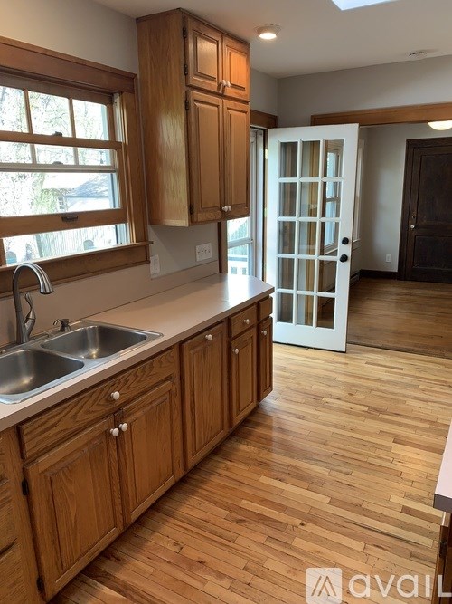 A kitchen with wooden cabinets and a white sink.