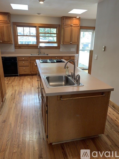 A kitchen with wooden cabinets and a stainless steel sink.