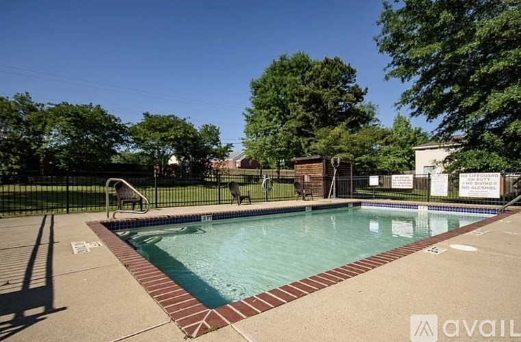 A pool surrounded by a black fence with a sign that says "NO ALCOHOL".