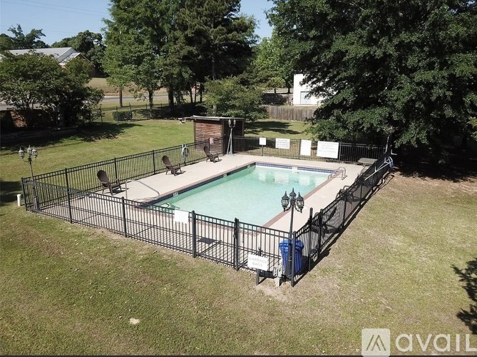 A black fenced in pool surrounded by trees.