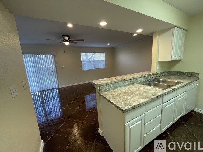 A kitchen with a marble countertop and white cabinets.