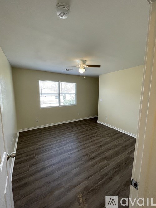 A room with wooden flooring and a ceiling fan.