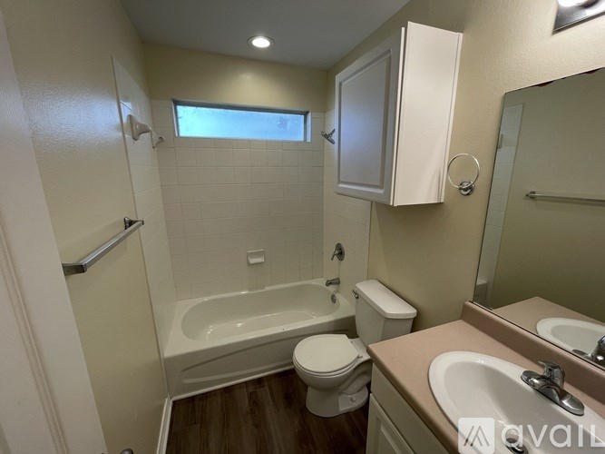 A bathroom with a toilet, sink, and bathtub.