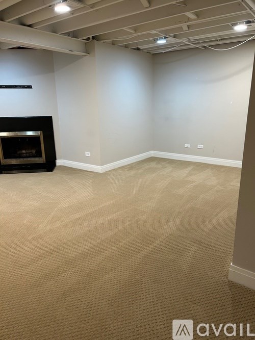 A room with a fireplace and carpeted floor.