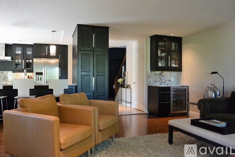 Two tan chairs are in front of a black cabinet.