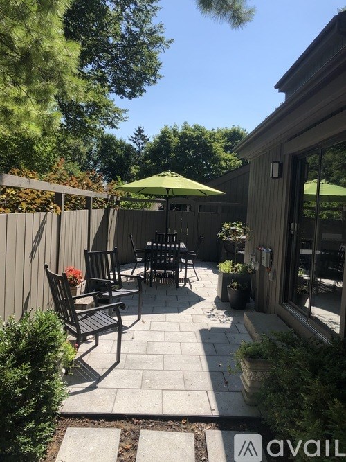 A patio with a table and chairs under an umbrella.