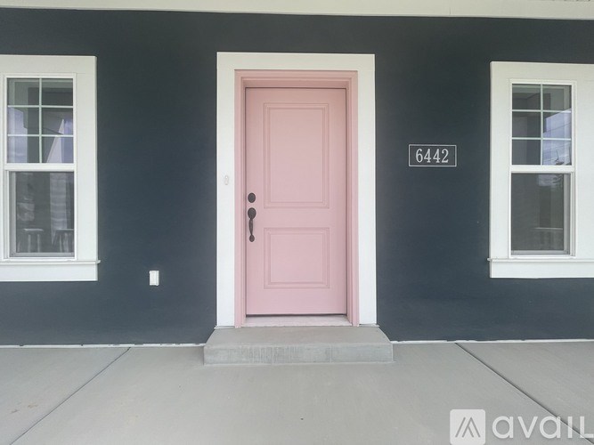 A pink door with a number 6442 on the wall.