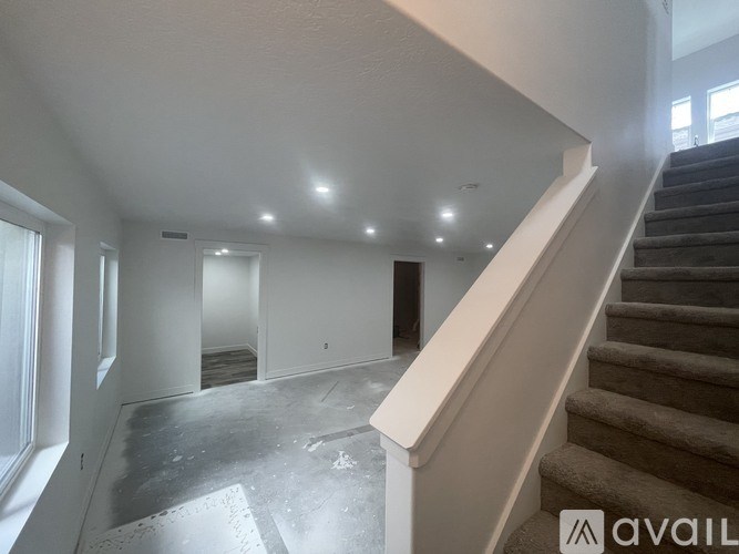 A spacious, empty room with a staircase leading to another level.