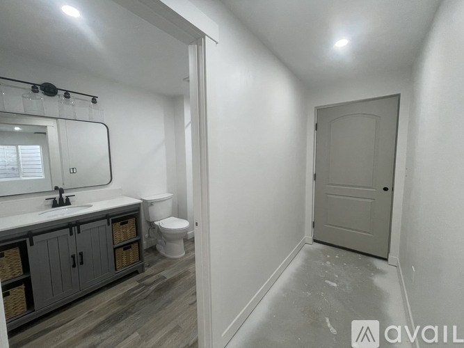 A bathroom with a toilet, sink, and mirror.