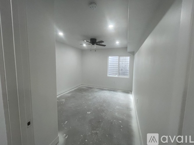 A room with a fan and a window.