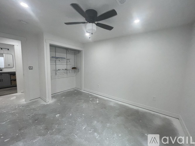 A spacious room with a ceiling fan and a walk-in closet.