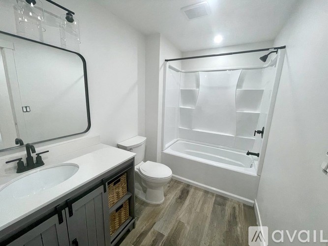 A bathroom with a toilet, sink, and a walk-in shower.