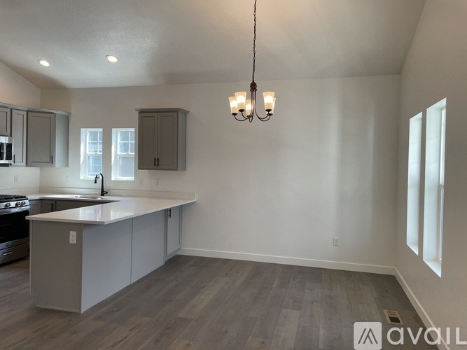 A kitchen with a large island and a chandelier hanging from the ceiling.