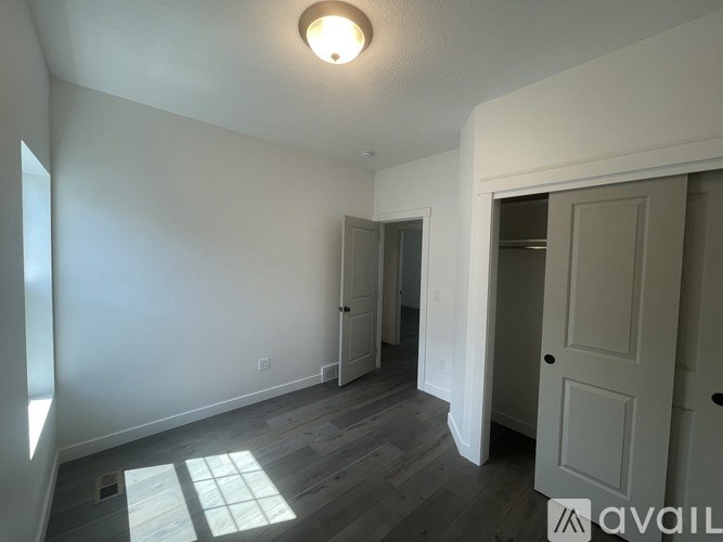 A room with a white door and a window with sunlight coming through.