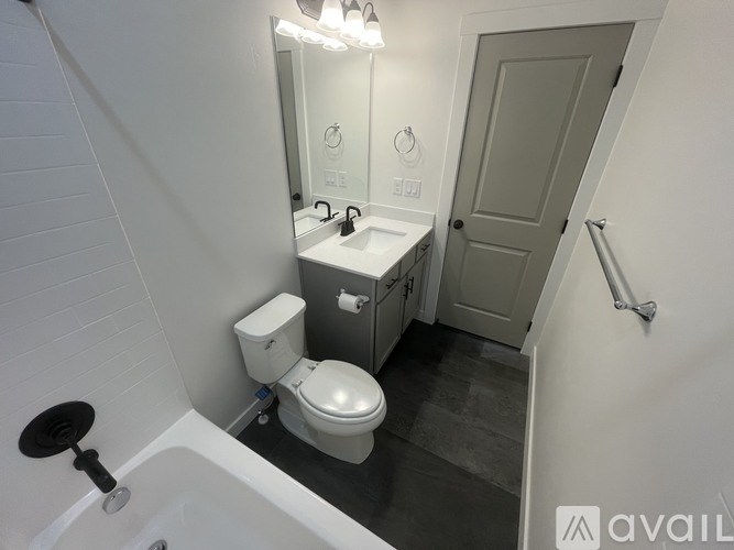 A bathroom with a toilet, sink, and mirror.