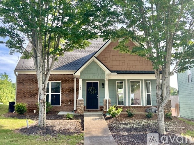 A small house with a black door and a brick wall.