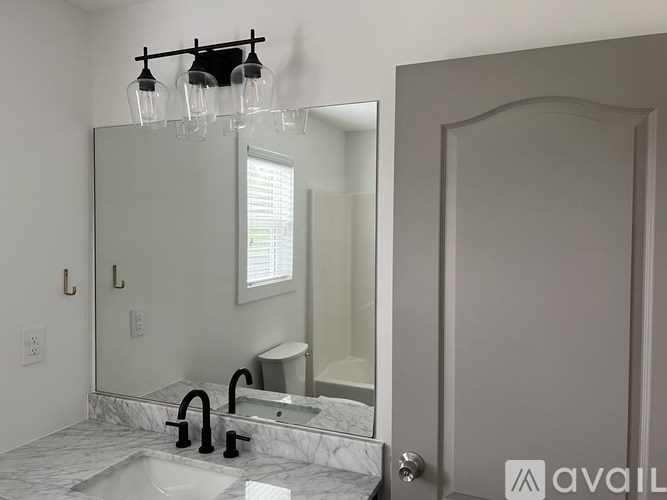 A bathroom with a marble countertop and a large mirror above the sink.