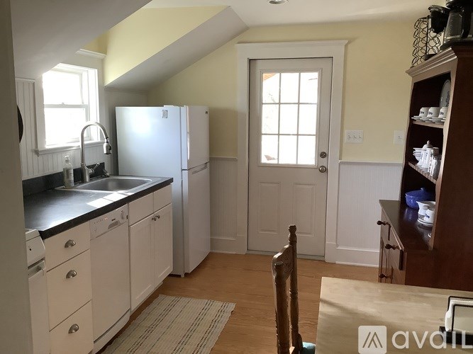 A kitchen with white cabinets and a black countertop.