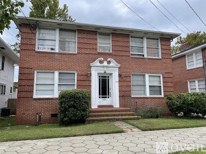 A red brick house with a white door and windows.