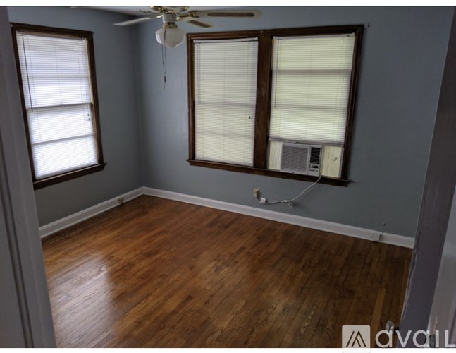 A room with wooden floors and a ceiling fan.
