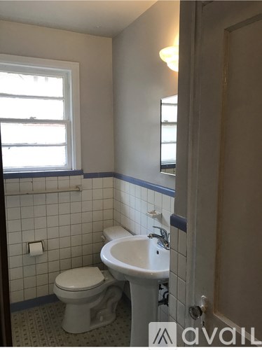 A bathroom with a toilet, sink and window.
