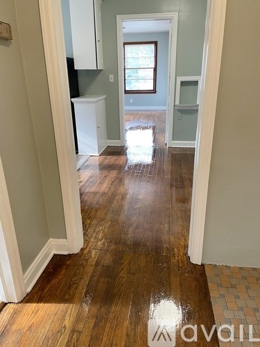 A hallway with wood floors and white walls.
