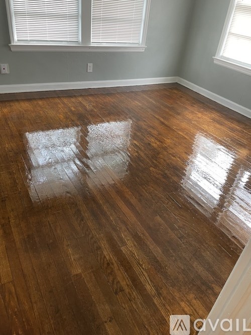 A room with wooden flooring and a window.