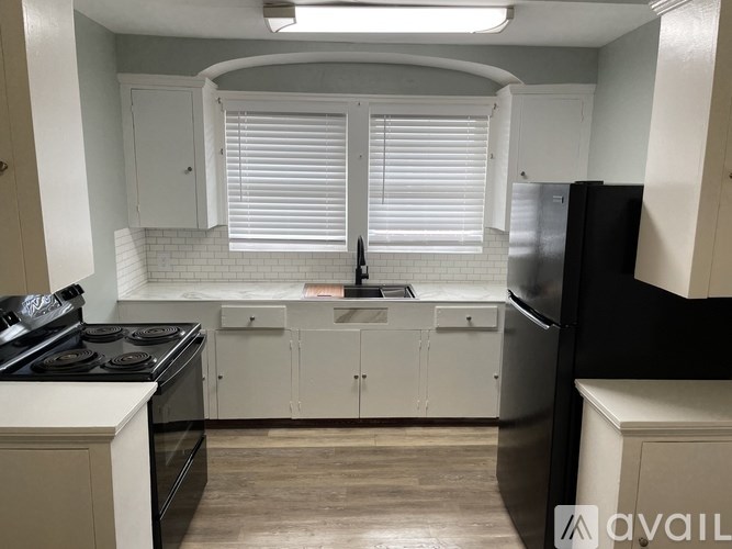 A kitchen with white cabinets and a black stove top oven.