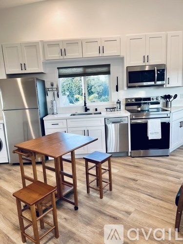 A kitchen with a wooden table and stools.