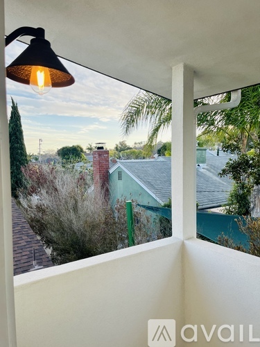 A view from inside a room looking out to a house with a red roof.