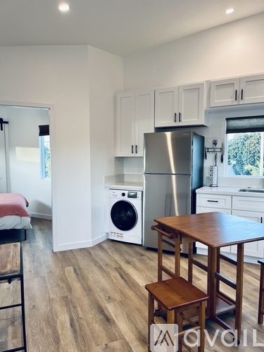 A kitchen with a washing machine and a refrigerator.