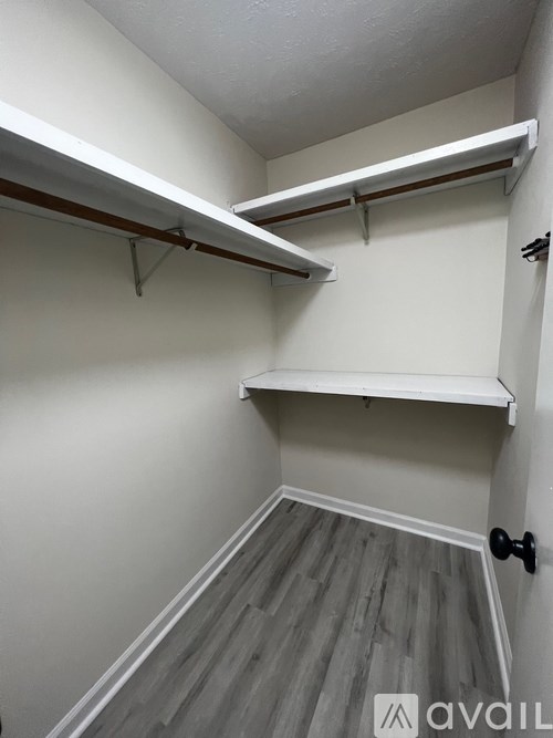 A white wall with a shelf and a door.