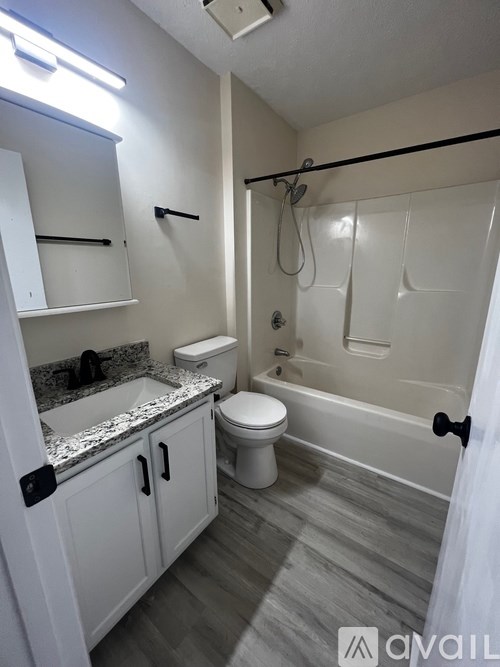 A bathroom with a toilet, sink, and bathtub.