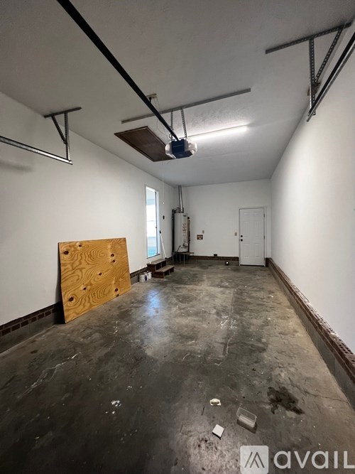 A room with a wooden board on the floor and a ceiling fan.