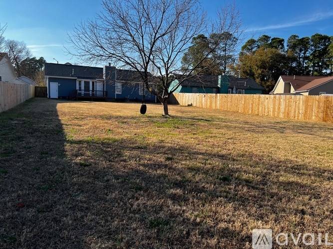 A backyard with a fence and a tree.