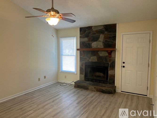 A room with a fireplace and a ceiling fan.