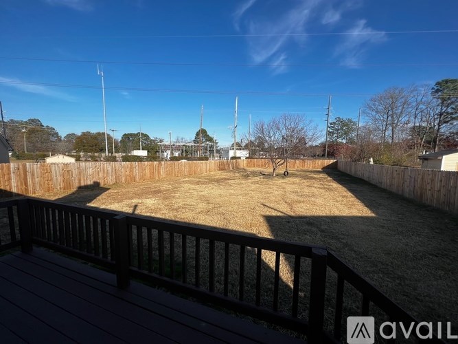 A backyard with a wooden fence and a deck.