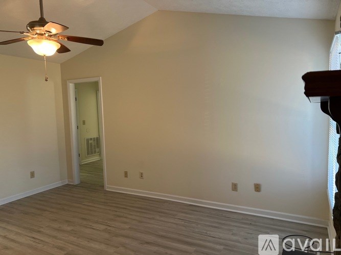 A room with a ceiling fan and wooden flooring.