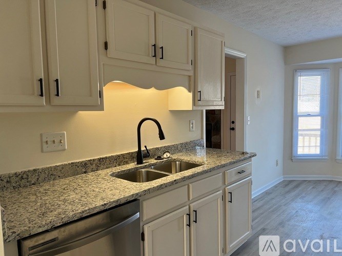 A kitchen with granite countertops and white cabinets.