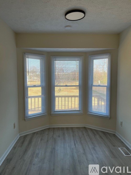A room with a large window and a wooden floor.