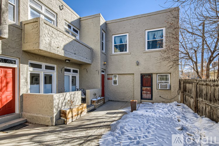 A house with a red door and a grey wall.