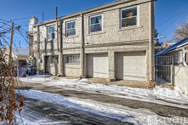 A large, old building with a grey stone facade and a garage door.