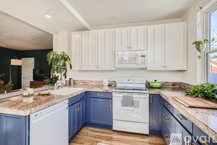 A kitchen with white cabinets and a white stove top oven.