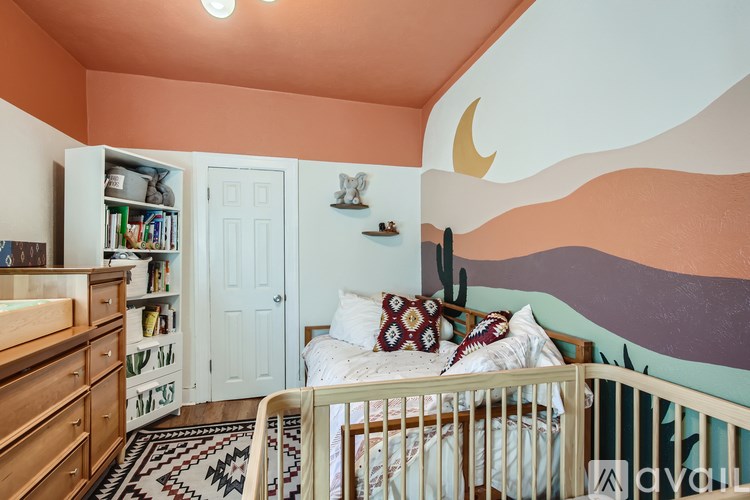 A baby's room with a white crib and a colorful mural on the wall.