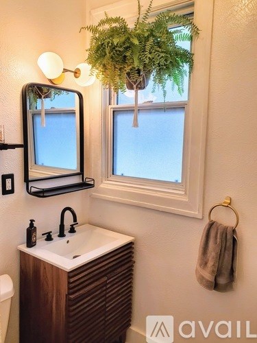 A bathroom with a white sink and a mirror above it.
