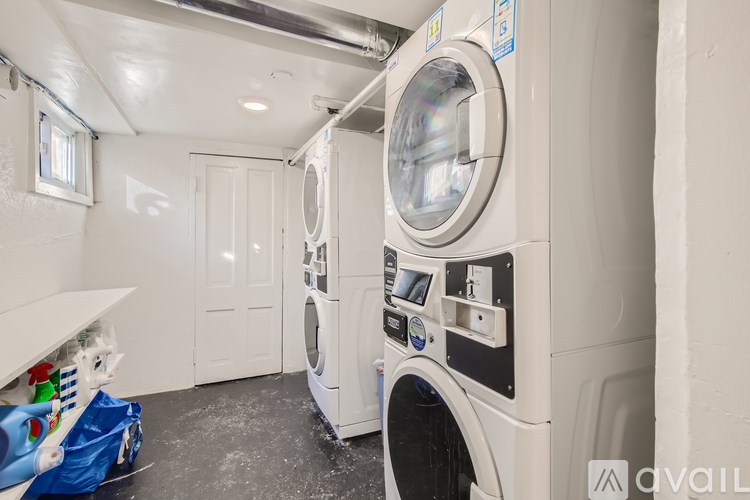 A washing machine in a small room with a door and a window.