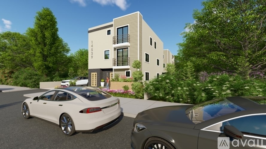 Two cars are parked in front of a modern building with trees in the background.