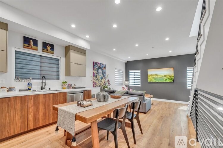 A modern kitchen with wooden cabinets and a dining table set for four.
