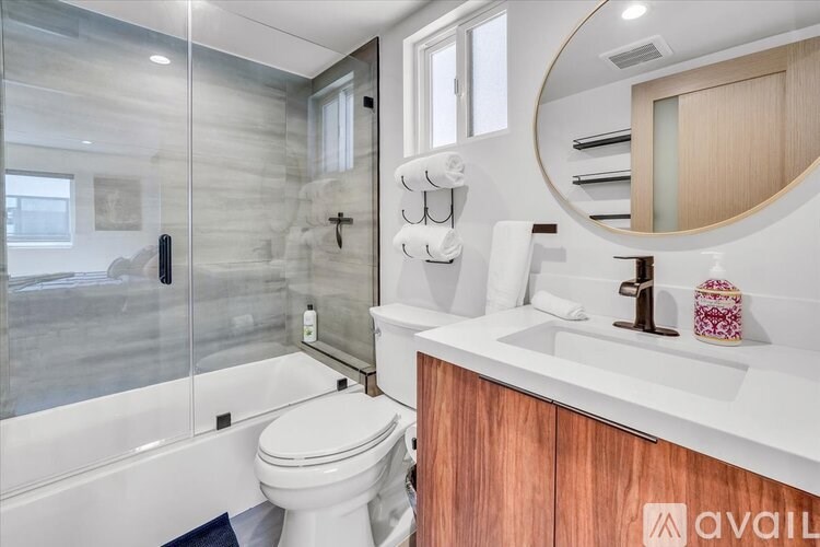 A modern bathroom with a white toilet and a wooden cabinet.